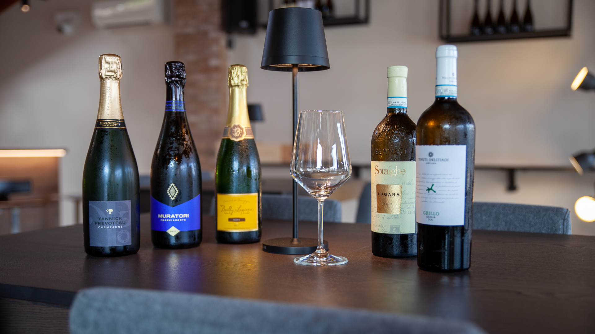 Bottiglie di vino e calice sopra tavolino